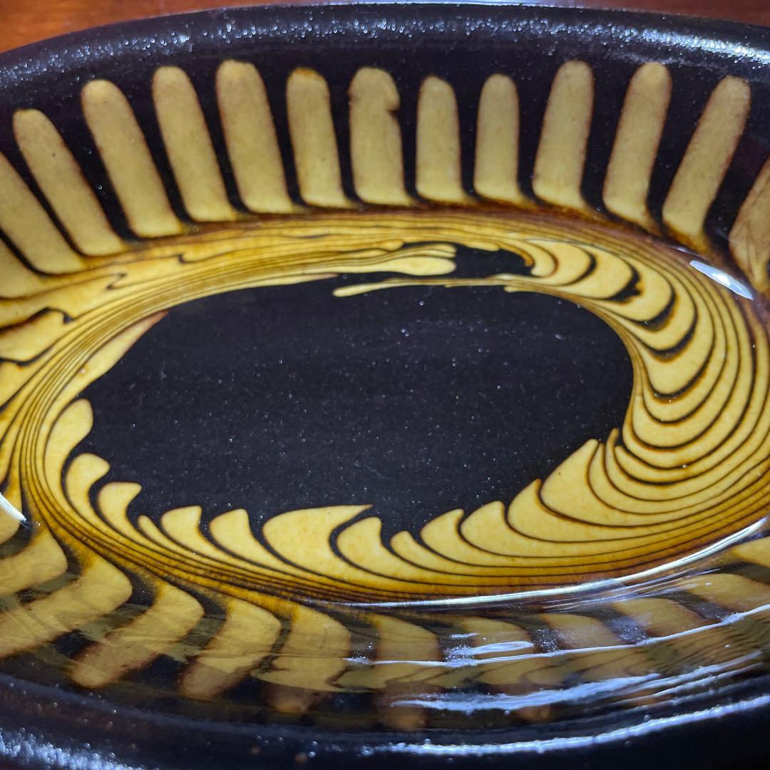 湯町窯陶器の楕円形皿 黒と黄の渦巻き模様