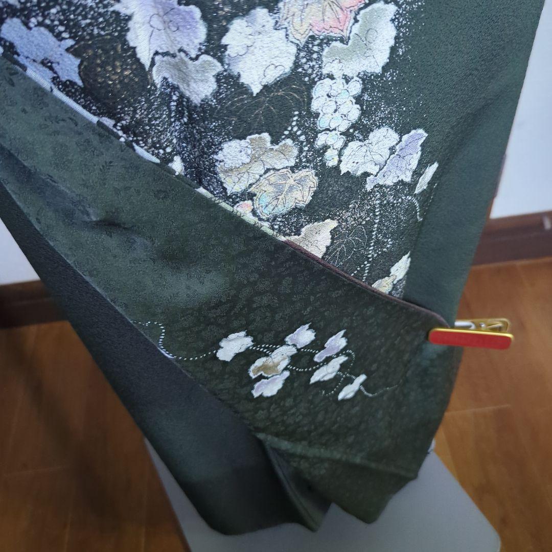 落款が入ります、青丹色の地に煌めく葡萄柄が繊細な美しさを見せる正絹訪問着です