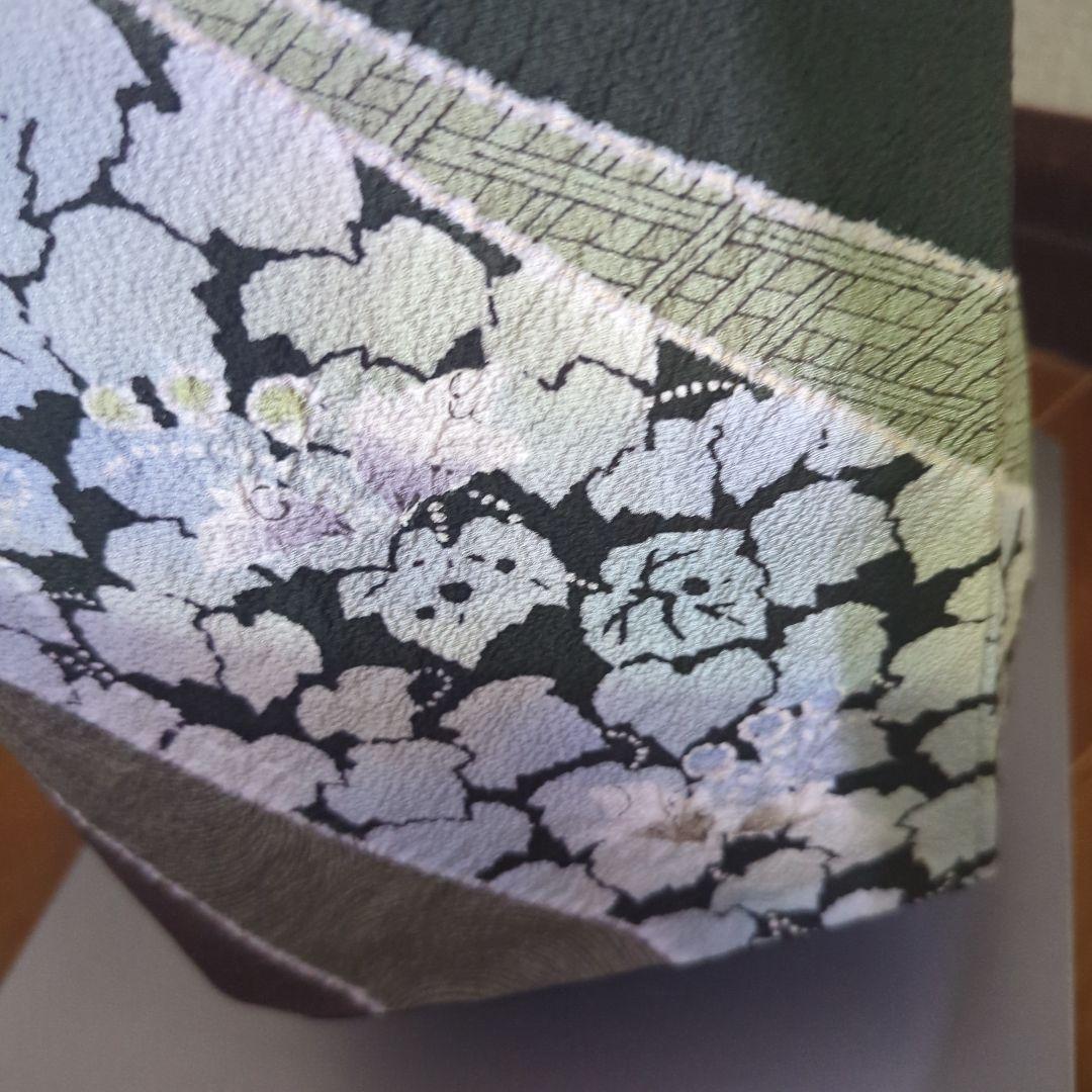 落款が入ります、青丹色の地に煌めく葡萄柄が繊細な美しさを見せる正絹訪問着です