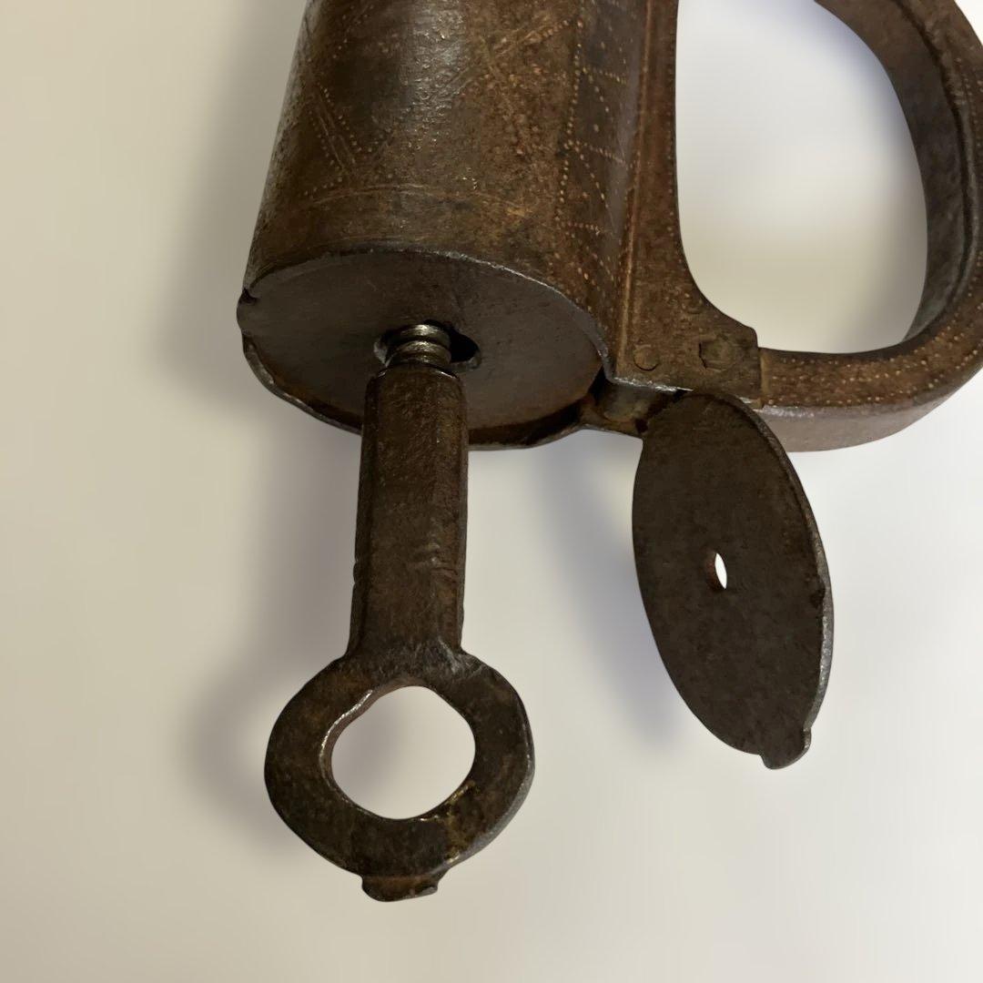 アンティークな鉄製スクリュー式円筒型南京錠（表面には点描幾何学模様）