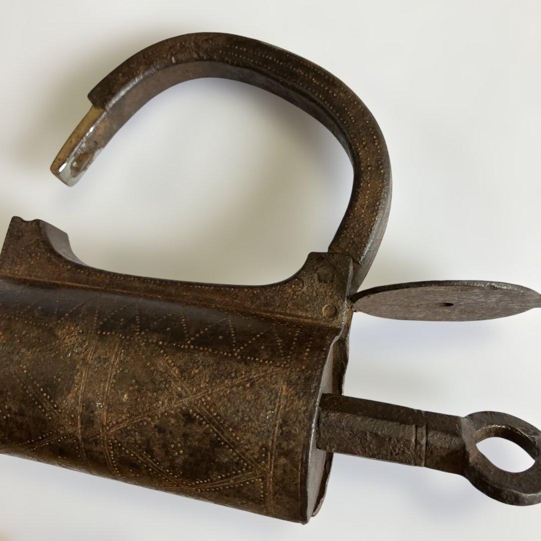 アンティークな鉄製スクリュー式円筒型南京錠（表面には点描幾何学模様）