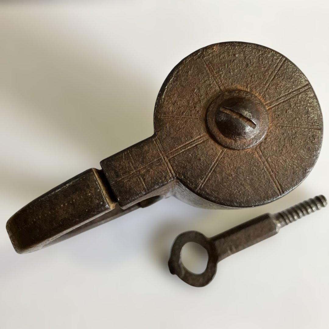 アンティークな鉄製スクリュー式円筒型南京錠（表面には点描幾何学模様）