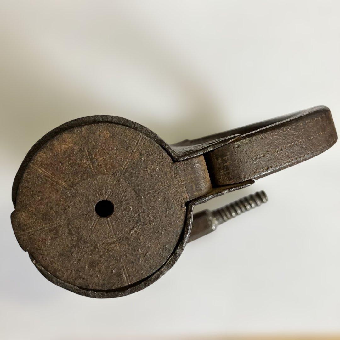 アンティークな鉄製スクリュー式円筒型南京錠（表面には点描幾何学模様）