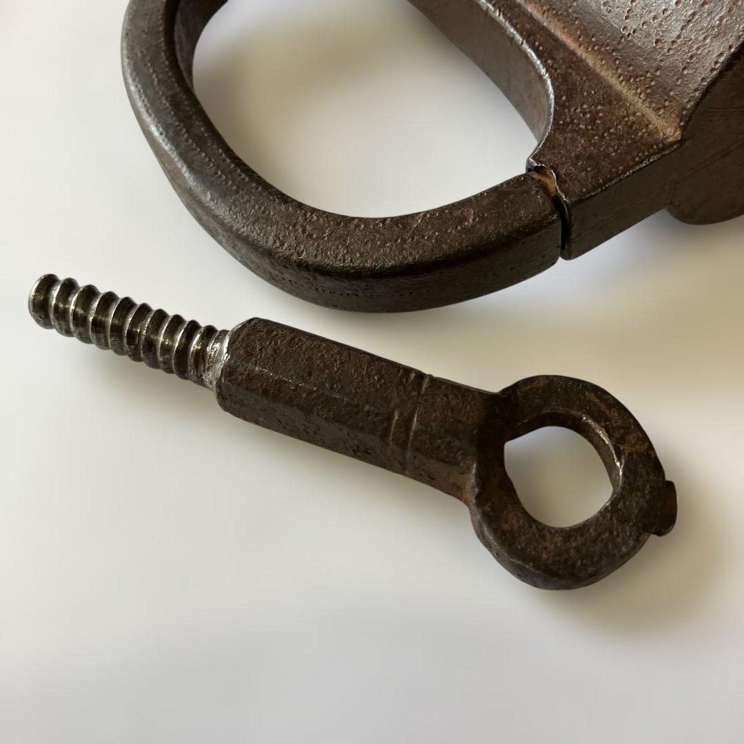 アンティークな鉄製スクリュー式円筒型南京錠（表面には点描幾何学模様）