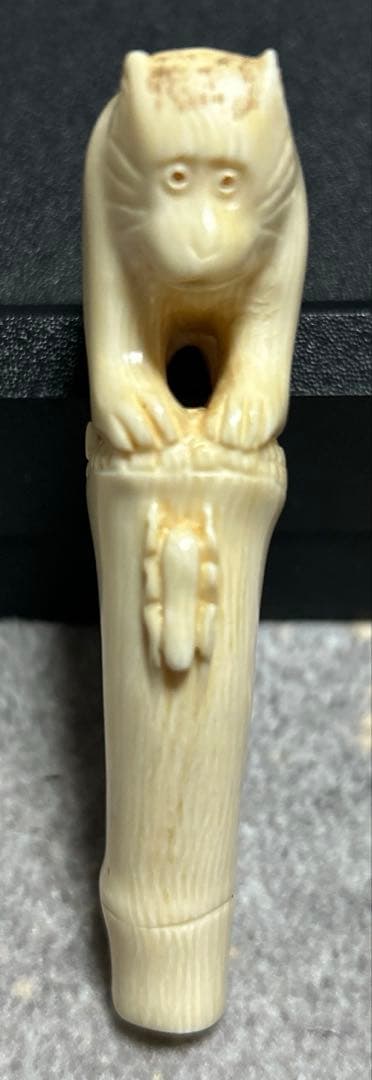 根付 竹の子に止まりバッタを見つめる猿の姿をしている根付