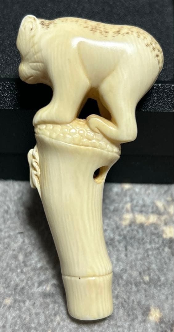 根付 竹の子に止まりバッタを見つめる猿の姿をしている根付