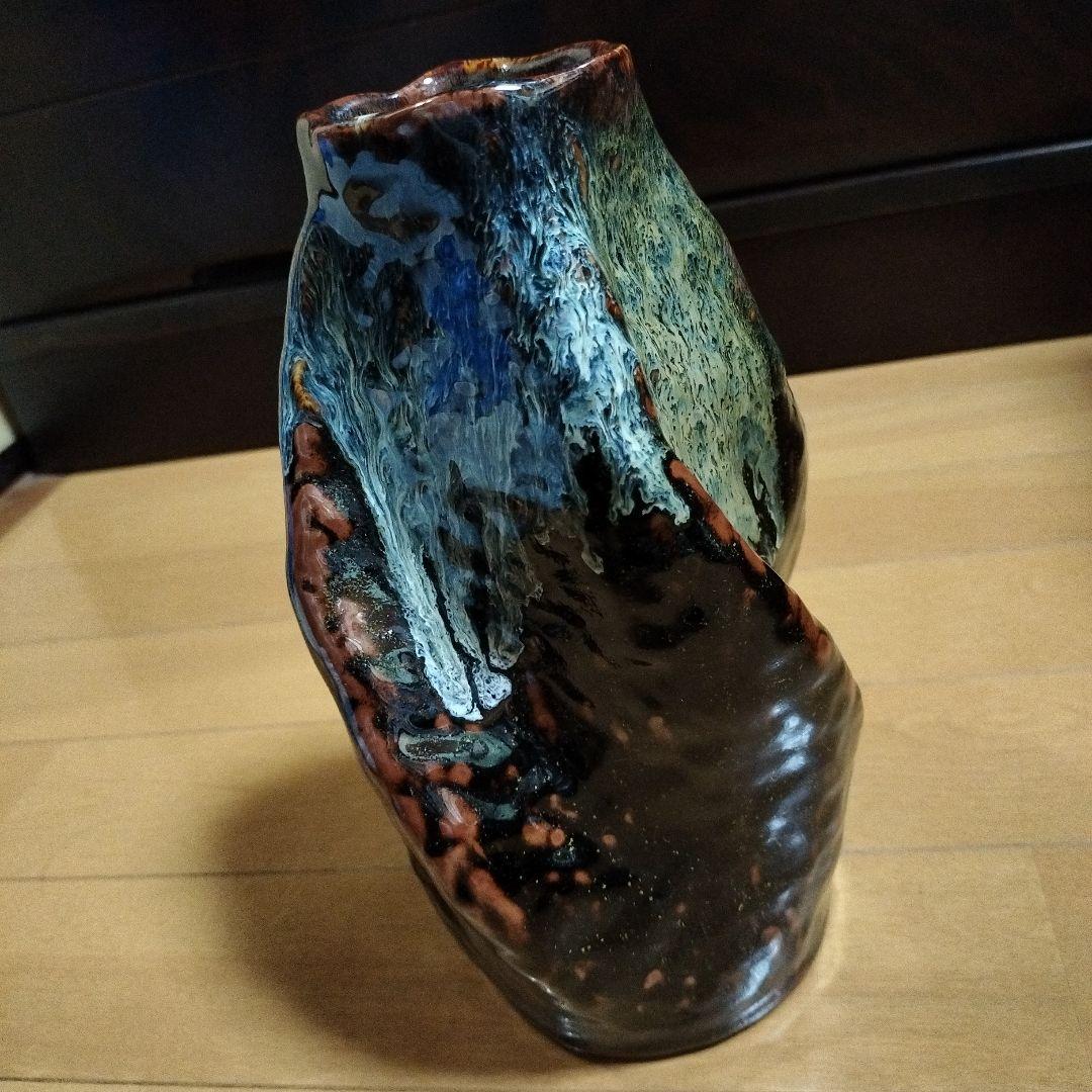 黒色地に青と白と茶の陶器花瓶