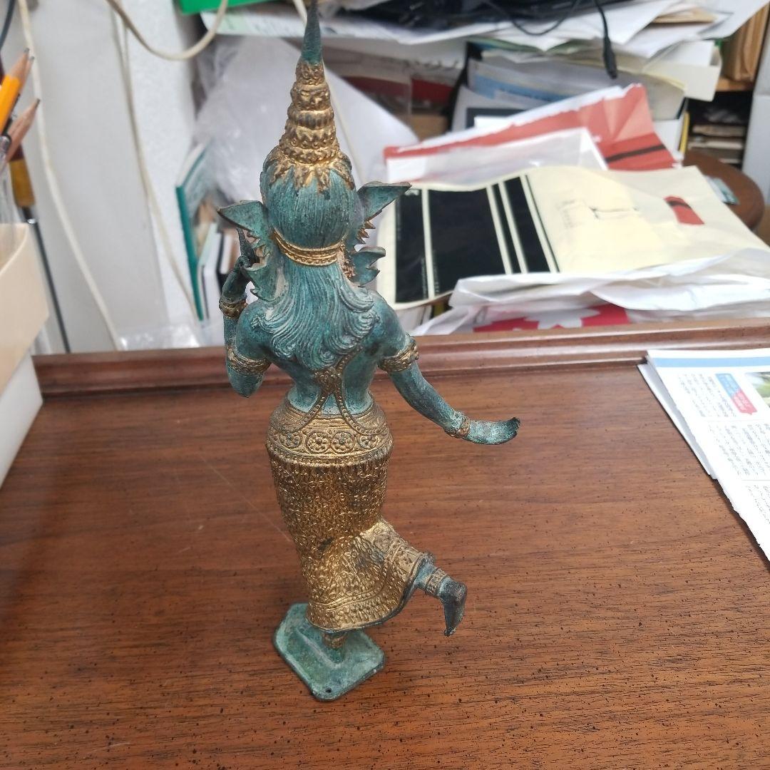 青銅色と金色のアジアの立像