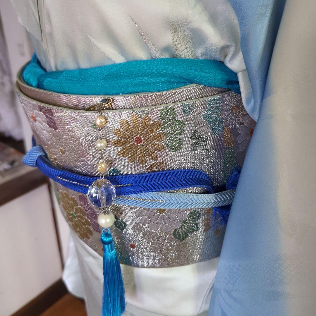 虹色に煌めくシルバーの地に、菊の花が艶やかに咲く、美しい正絹袋帯です