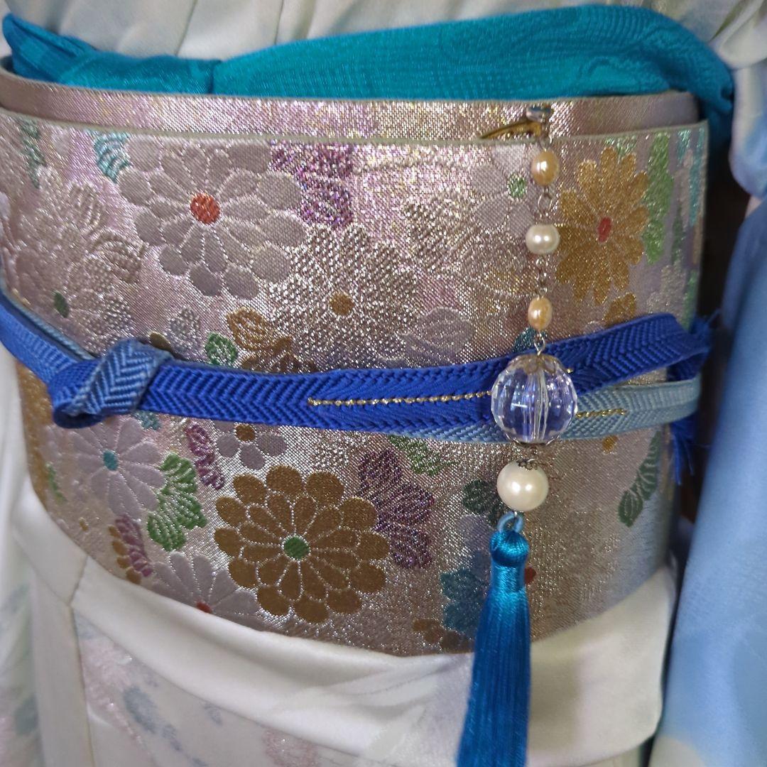 虹色に煌めくシルバーの地に、菊の花が艶やかに咲く、美しい正絹袋帯です