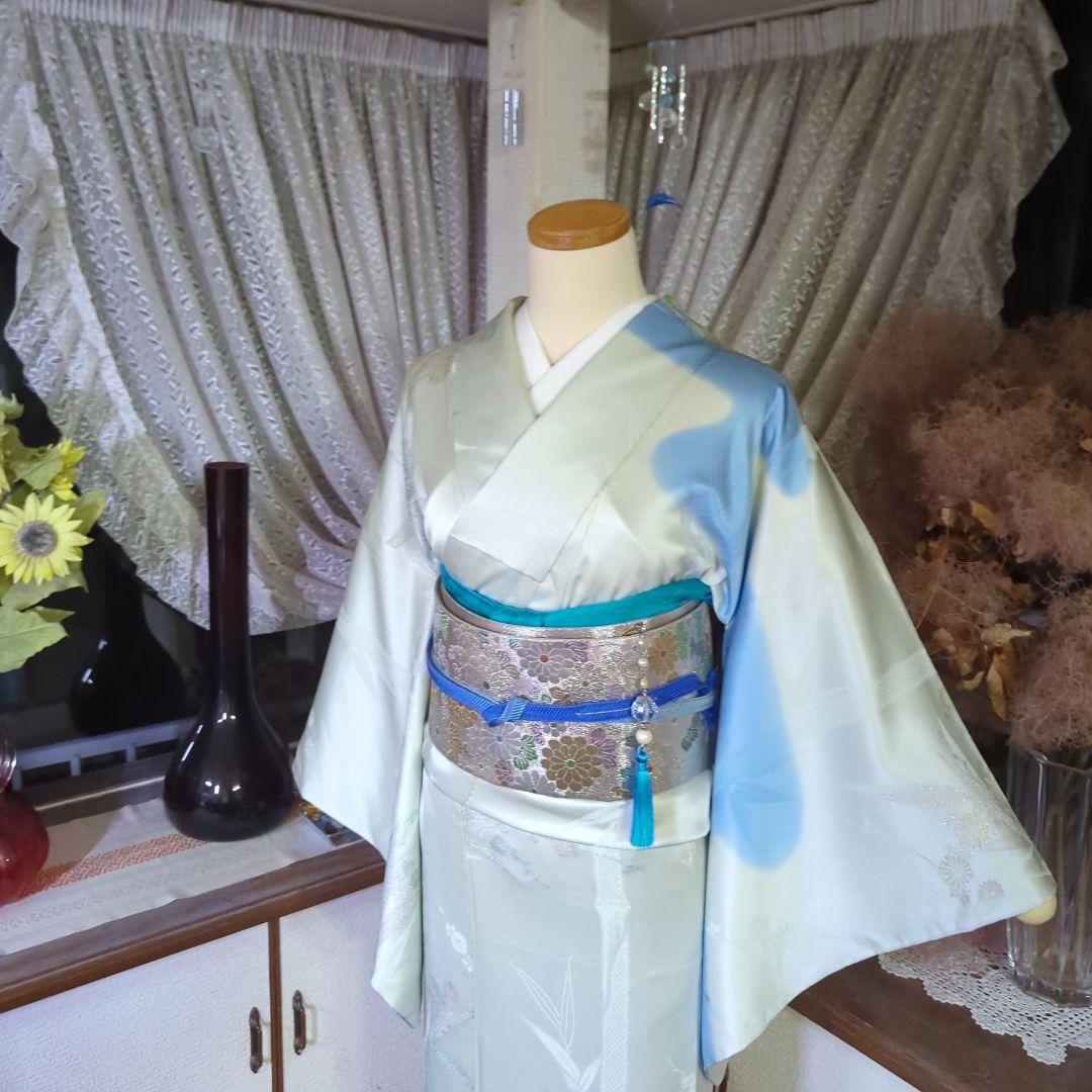 虹色に煌めくシルバーの地に、菊の花が艶やかに咲く、美しい正絹袋帯です