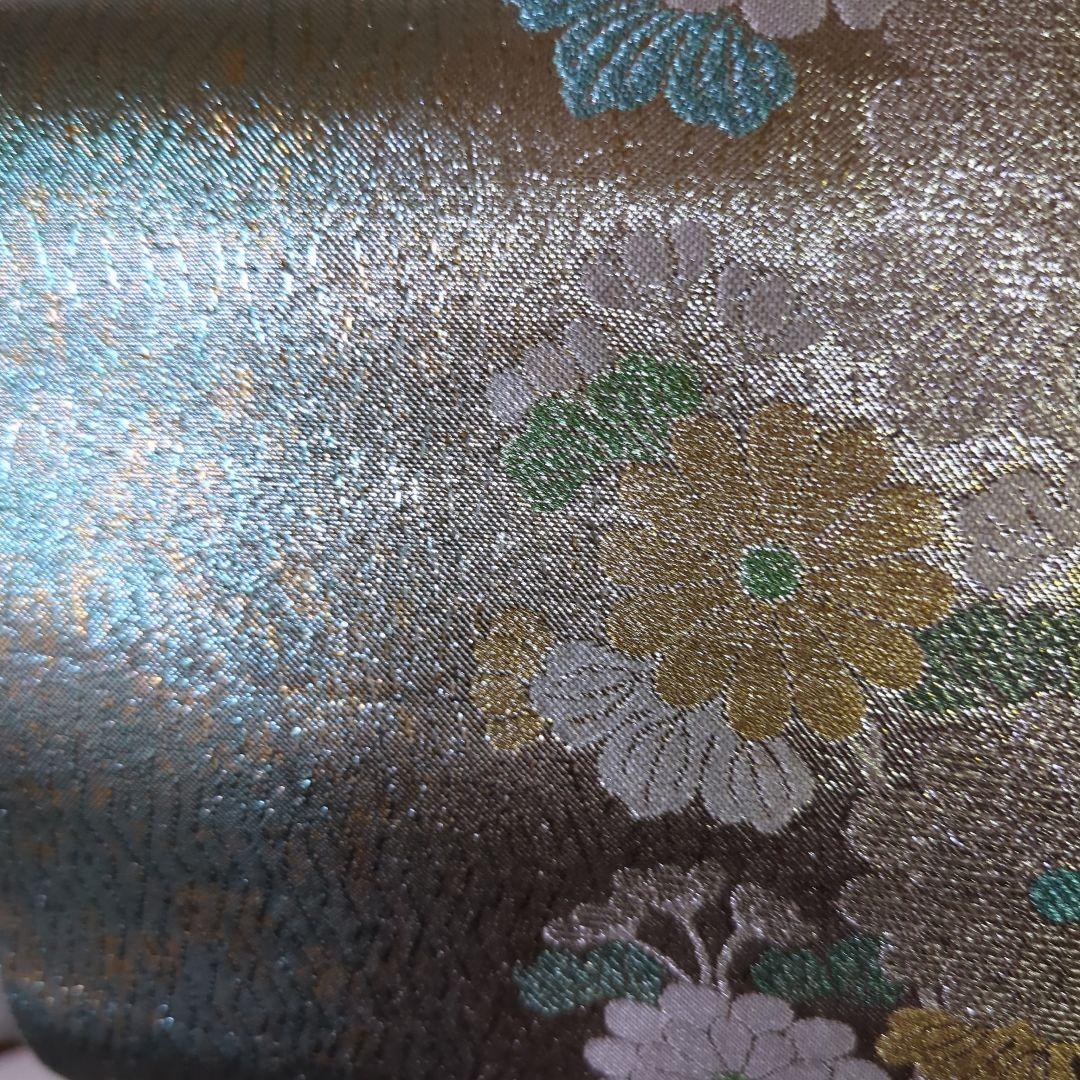 虹色に煌めくシルバーの地に、菊の花が艶やかに咲く、美しい正絹袋帯です