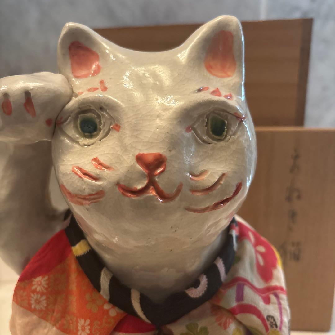 作家さんによる大きな瞳でにっこりと笑う着物の前掛けも美しい招き猫