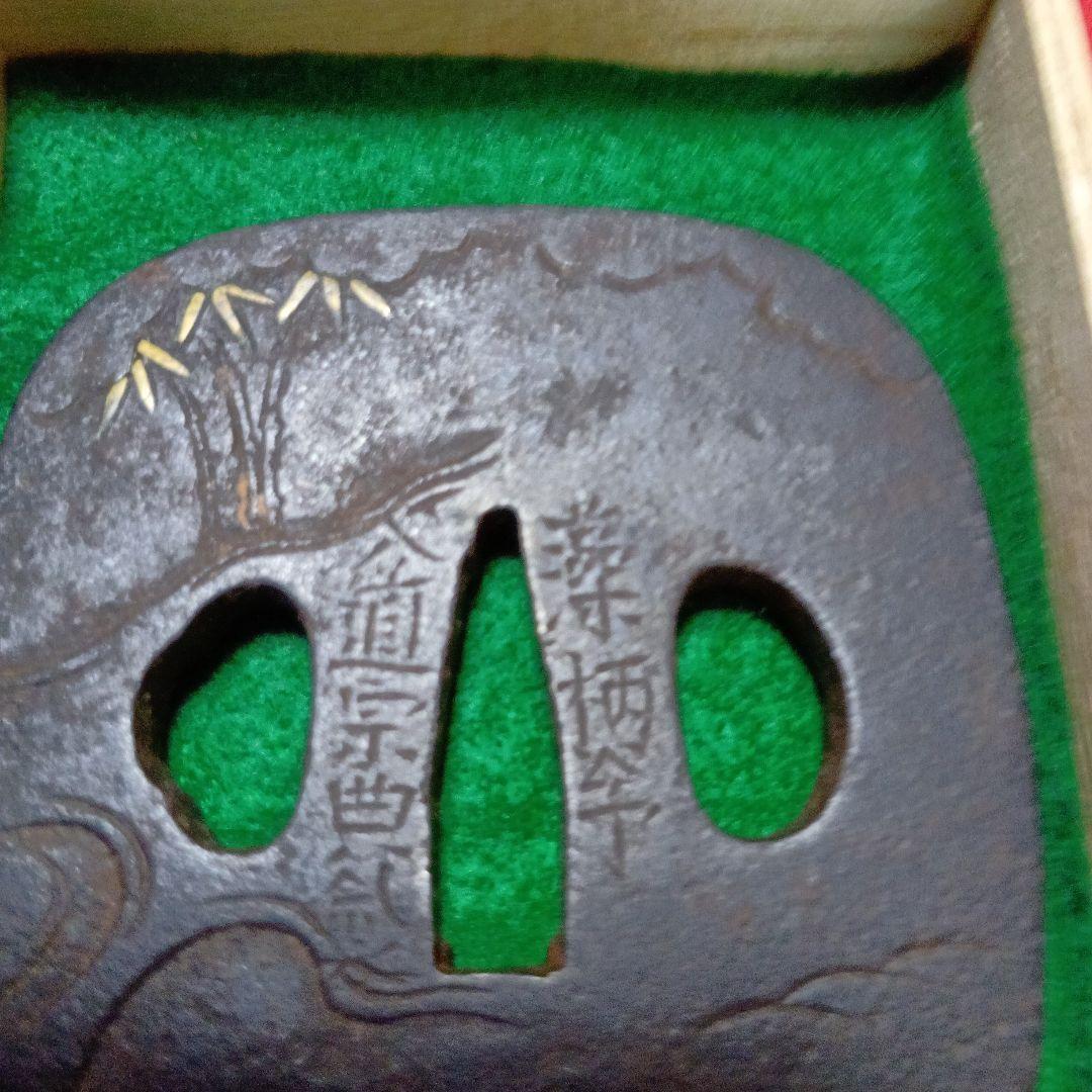 江州彦根住藻柄子入道宗典在銘の鉄製 鍔 竹の葉は金象嵌と山水の彫刻 木箱付き