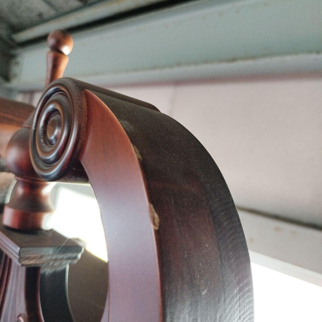 装飾的な文字盤と振り子を持つダークウッドの柱時計