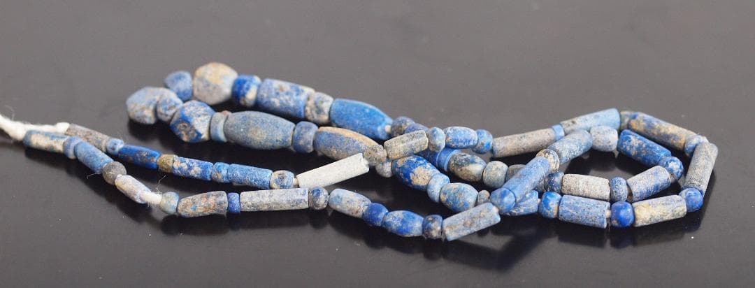古代濃紺ラピスの管玉や丸玉をほぼ左右対称に編み、トップに斧型や多面体、80個の連