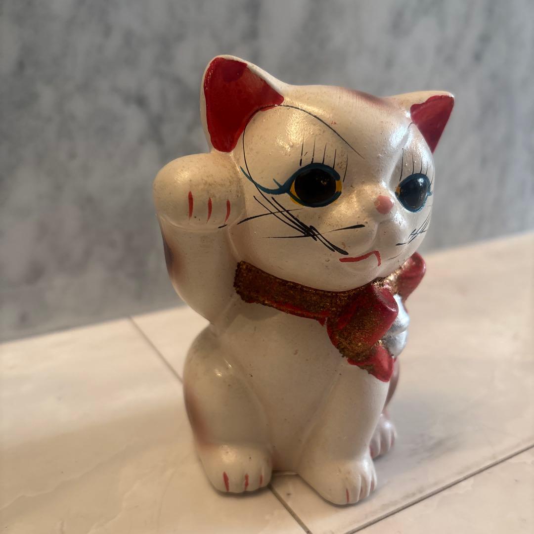 アンティーク大きな瞳や長いヒゲ、まつ毛が美しく、大きなリボンも可愛い招き猫